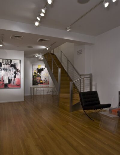 Modern art gallery interior with various artworks and seating available.