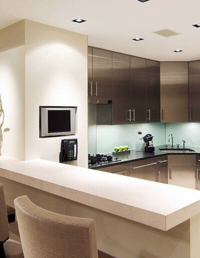 A modern kitchen with stainless steel appliances, recessed lighting, and a breakfast bar.